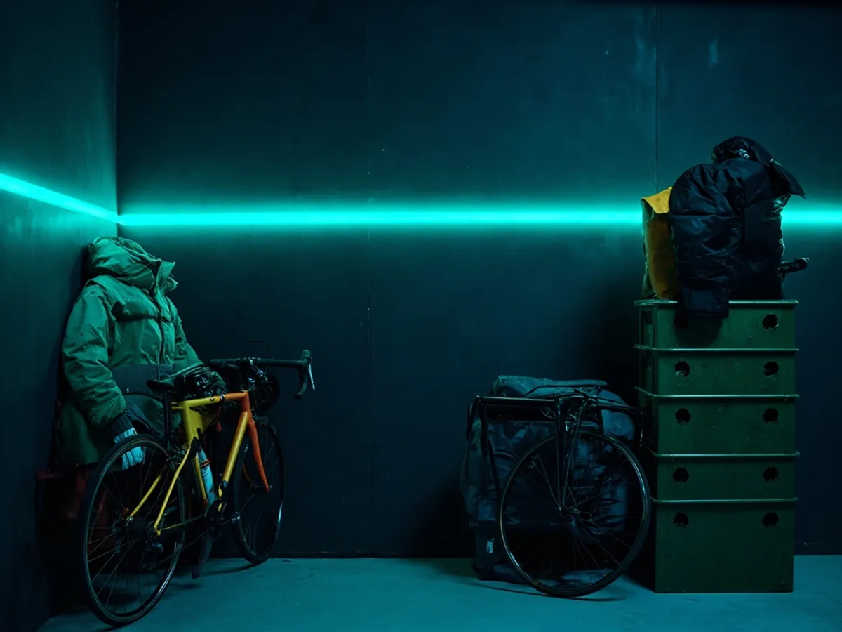 Off-season stock stored on basement shelves: vacuum-packed coats, crates and a bike