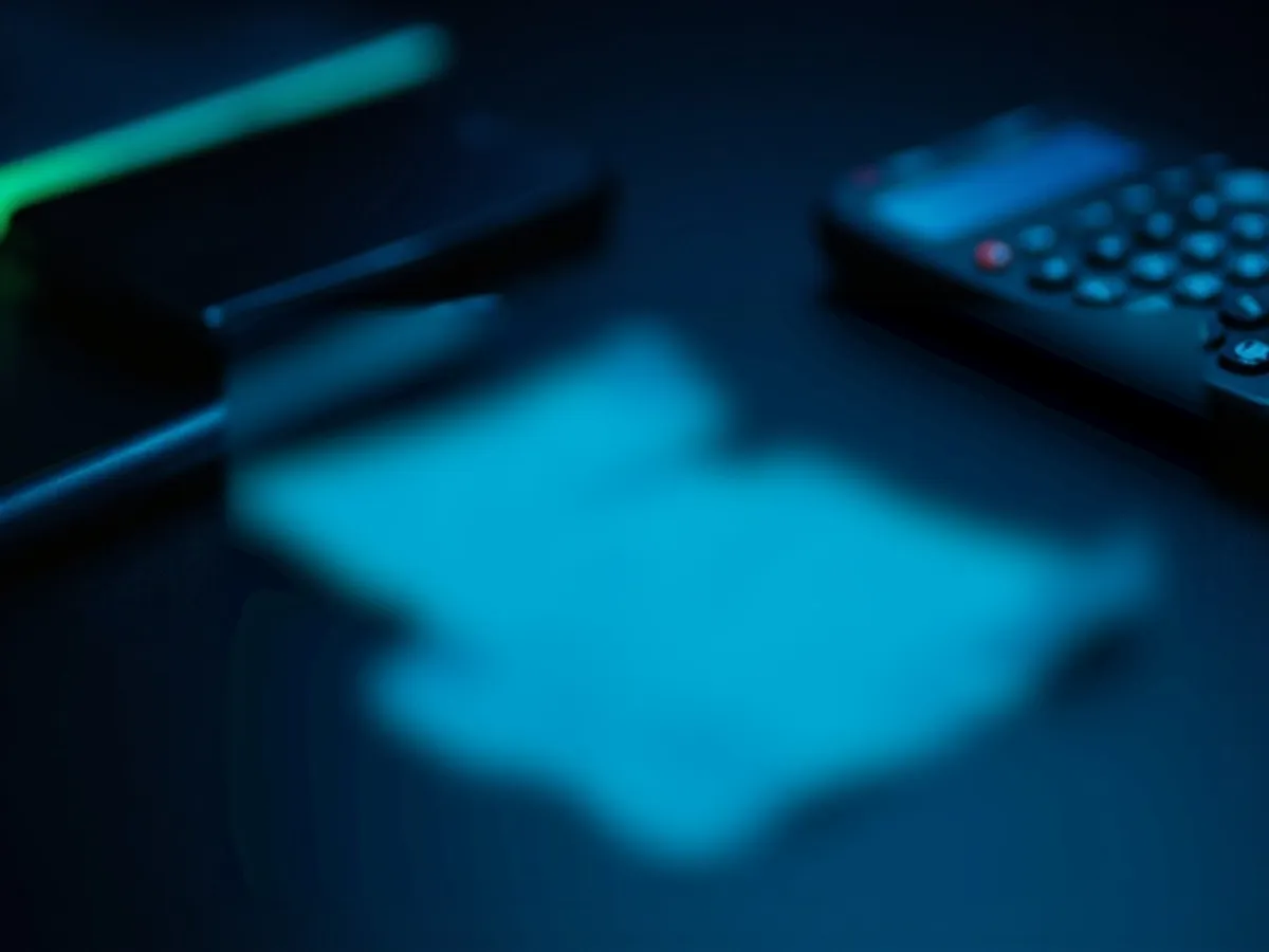 Torn receipt pieces on desk next to calculator and pen
