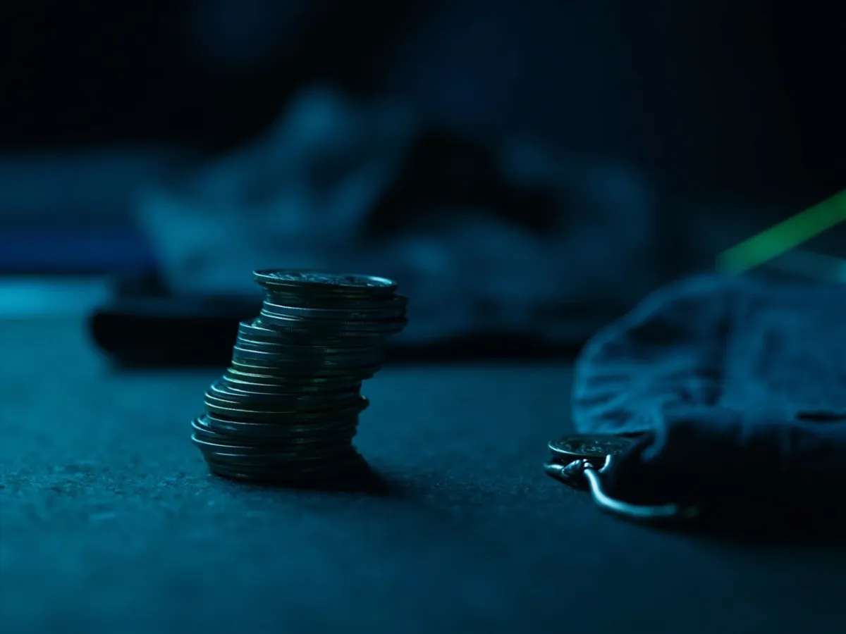 A folded jacket between two stacks of coins of different heights