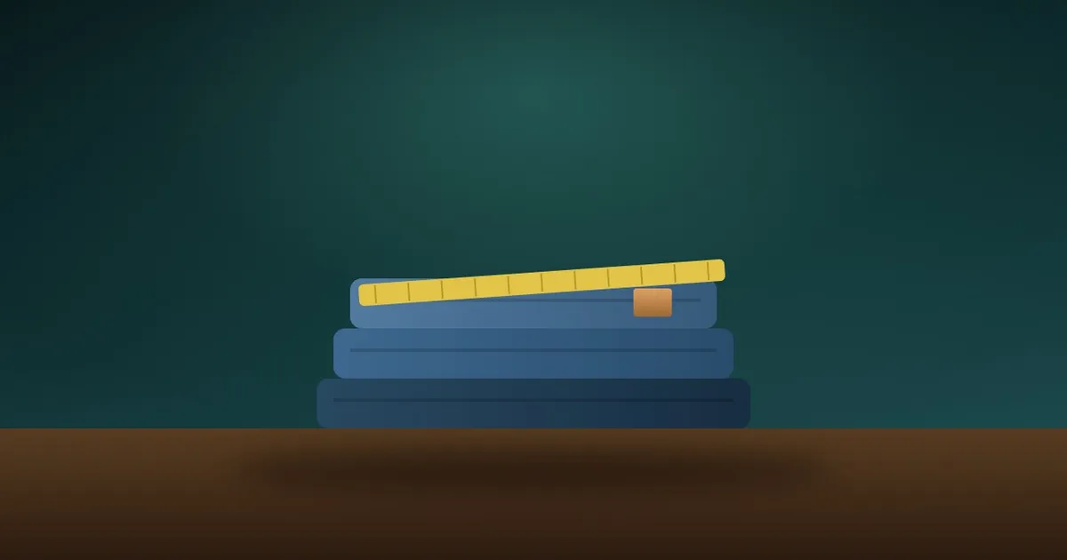 A stack of folded blue jeans in different washes with a tape measure across the top pair