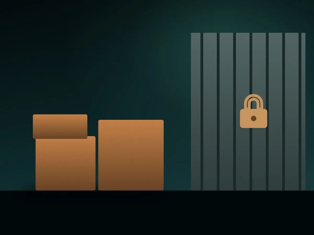 Stack of unmarked boxes behind a padlocked warehouse gate at night