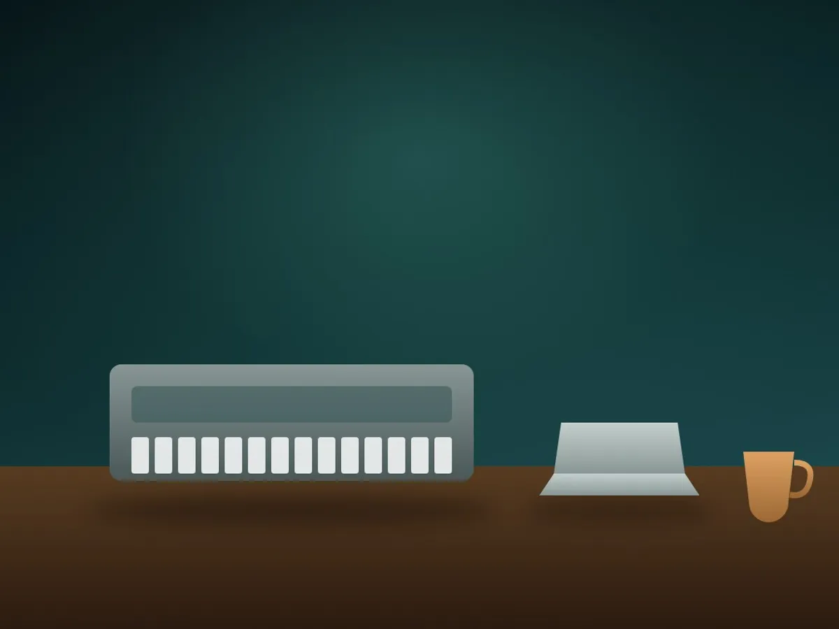 A rare boxed vintage synthesiser on a table beside a laptop and a cup of coffee