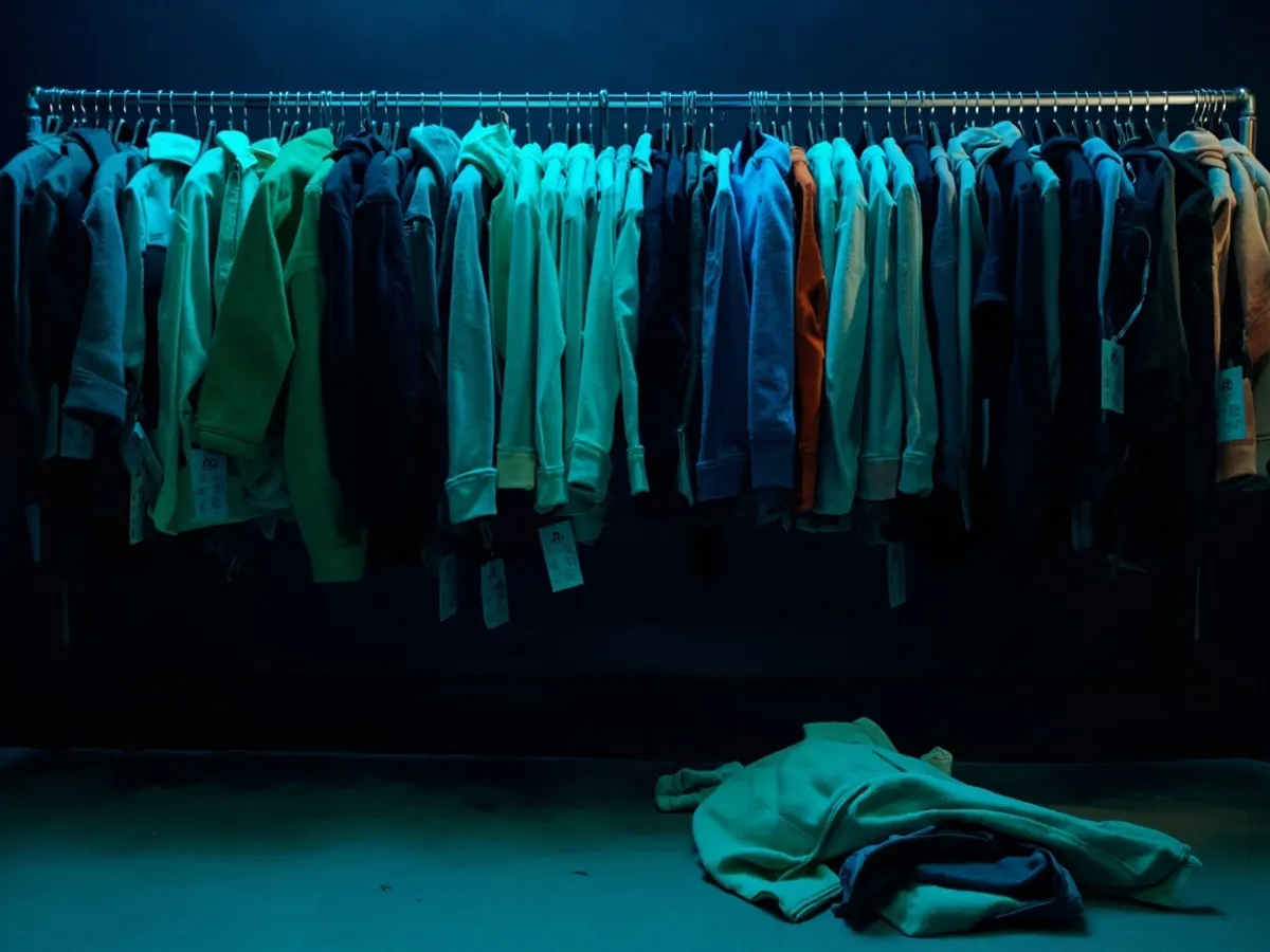 Clothing rail overloaded with identical fleece jackets in many colours