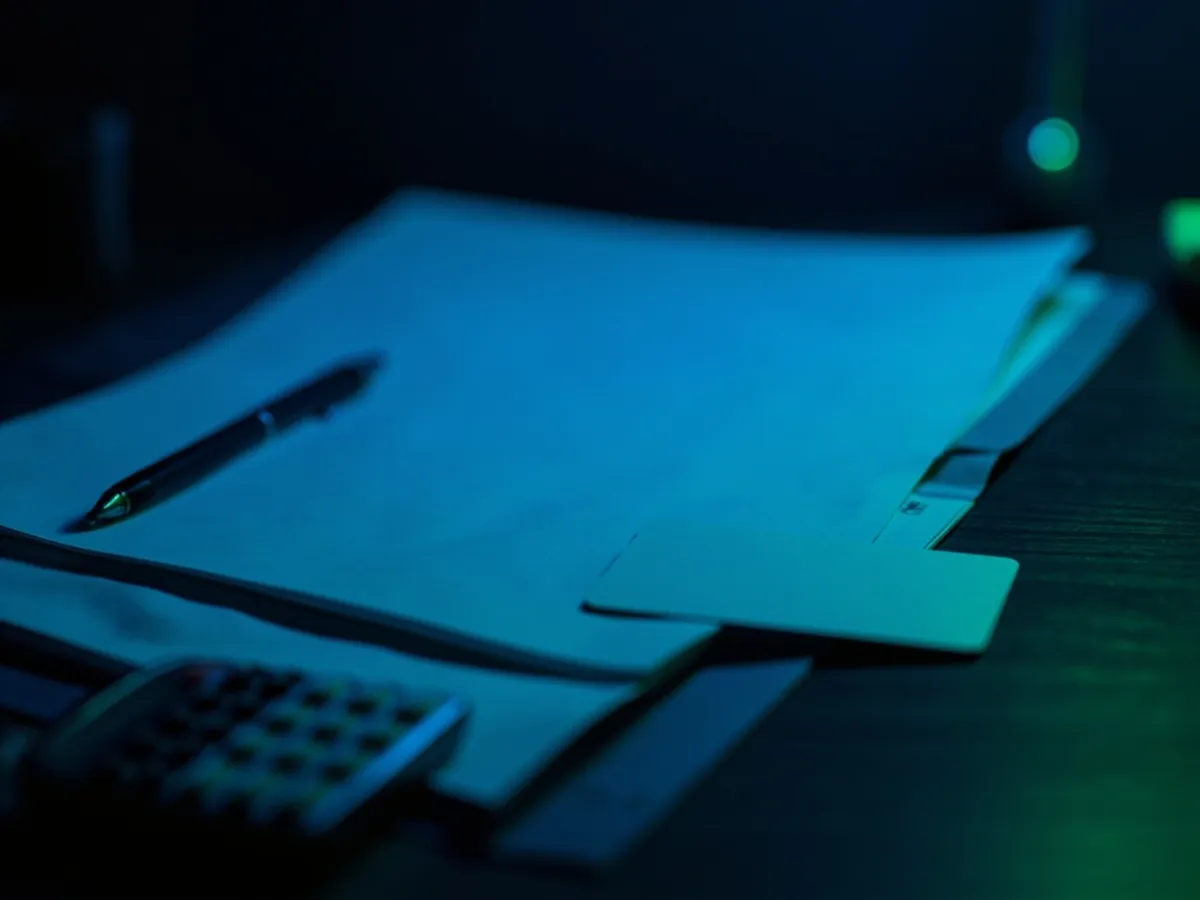 Folder with blank sheets, pen, blank residence card and calculator on a desk