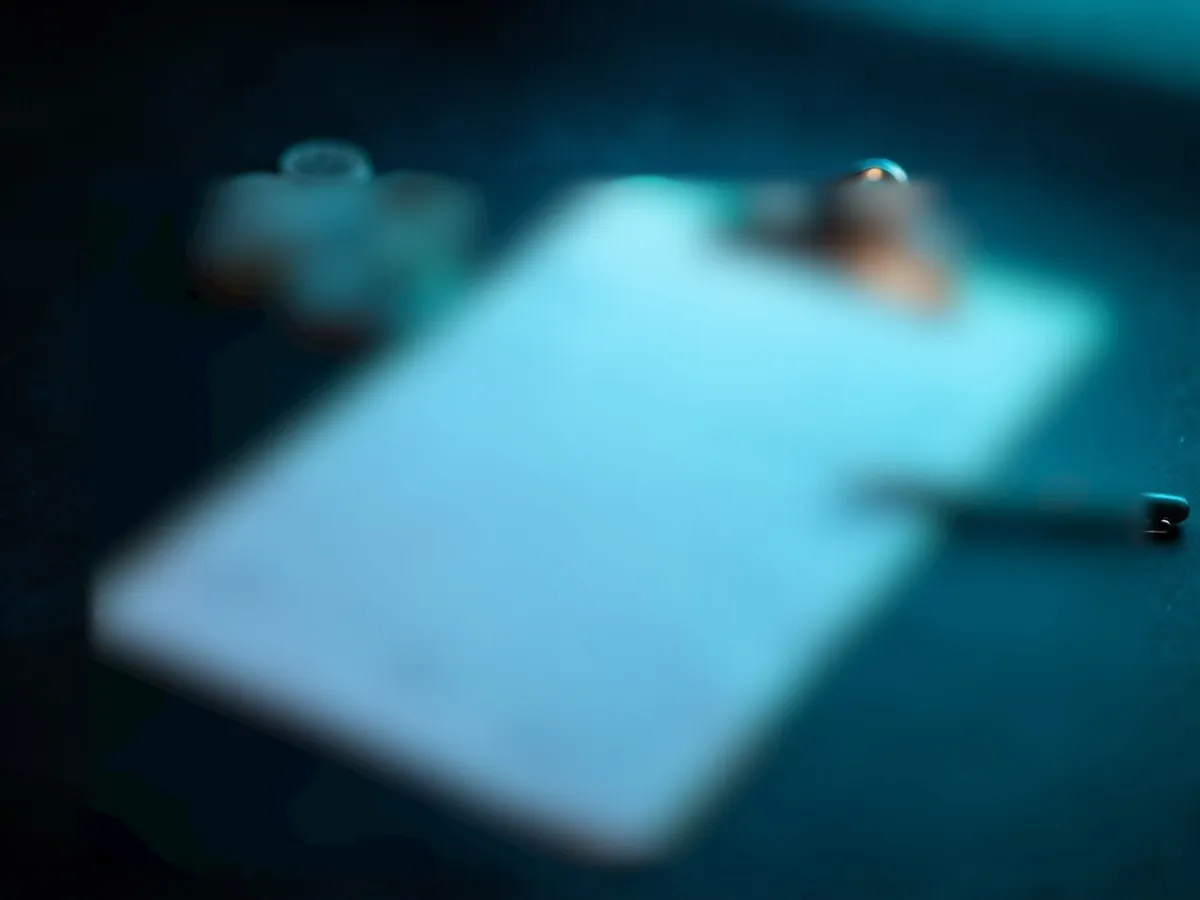 Blank grid sheet on a clipboard with a pen and coins