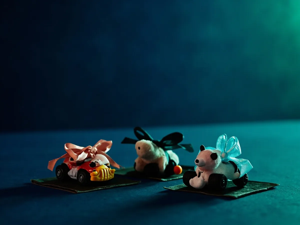 Three themed toy bundles tied with ribbon: vehicles, animal figures and plush toys