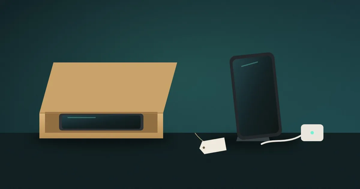 A used phone packed in a trade-in mailer beside another phone and a charger set up for a private sale