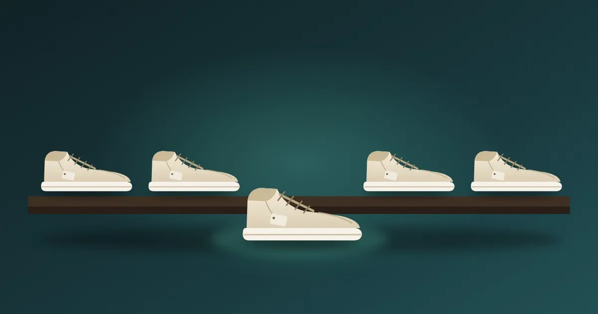 A row of five nearly identical white sneakers on a shelf, each with a small blank paper tag, one pushed slightly forward