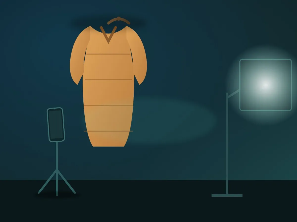 a knitted cardigan on a hanger photographed with a phone on a small tripod and a softbox light