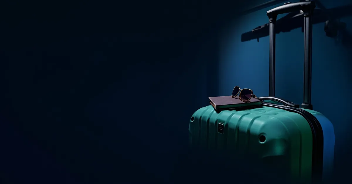 A packed suitcase standing beside a clothing rail covered with a light dust sheet