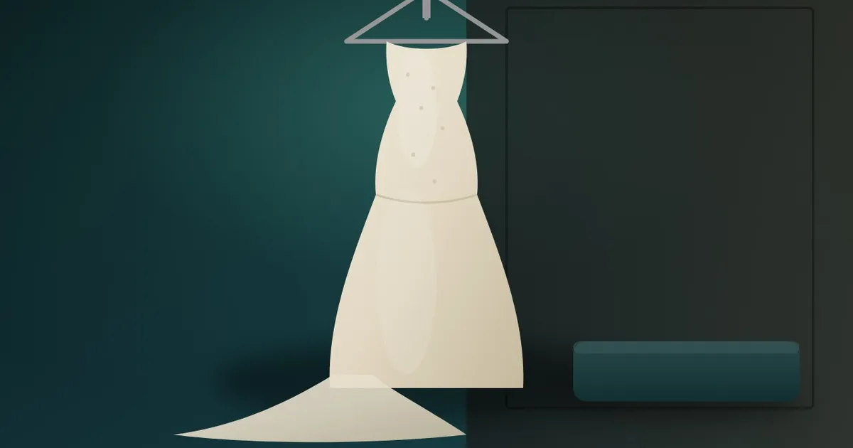An ivory lace wedding dress on a padded hanger with its train spread on the floor